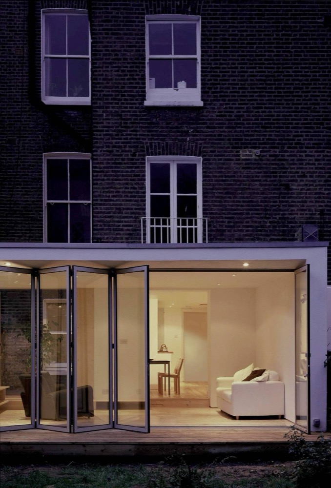 A Maida Vale flat with folding glass doors opening onto a garden room