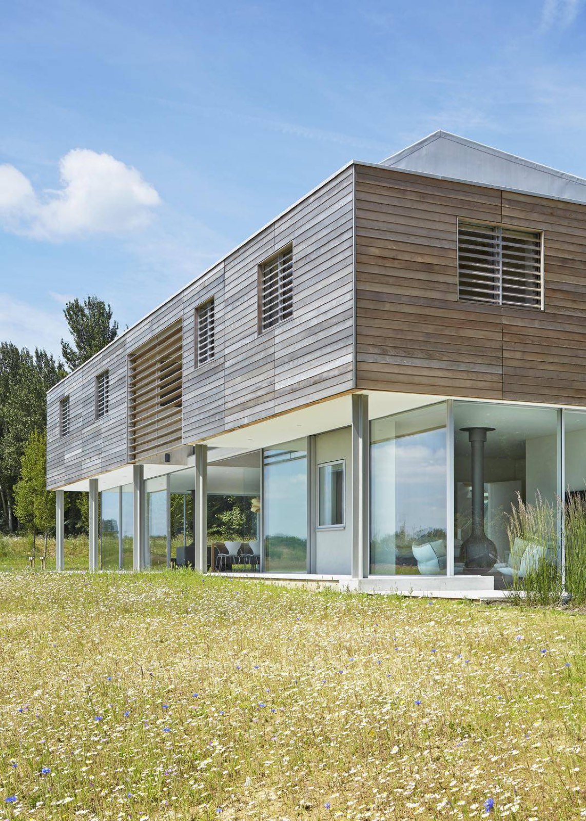 Sussex House, a timber-clad home with a steep gabled roofline in open countryside